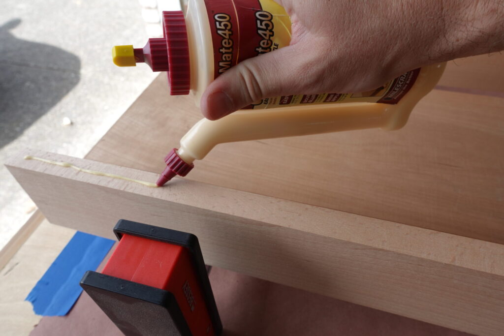 Adding glue to the edges of boards to be clamped